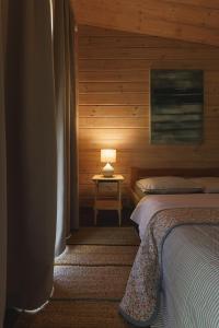 a bedroom with two beds and a table with a lamp at Obuoliu sala Moletu Vila in Gaylyunay