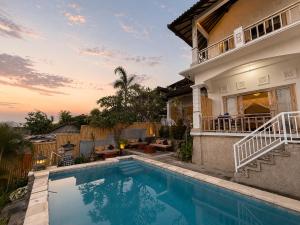 a house with a swimming pool in front of a house at SūKha Amed in Culik