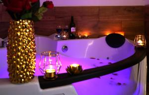 a bath tub with candles and a vase with a bottle of wine at Jacuzzi Przemyska in Krakow