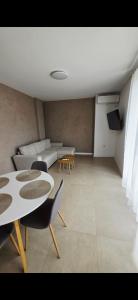 a living room with a couch and a table and chairs at CIty view apartment in Gotse Delchev