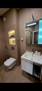 a bathroom with a sink and a toilet and a mirror at CIty view apartment in Gotse Delchev +8 photos