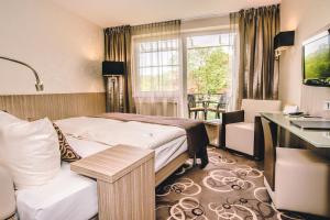 a hotel room with a bed and a desk at NordWest-Hotel Bad Zwischenahn in Bad Zwischenahn
