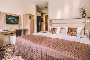 a hotel room with a large bed and a television at NordWest-Hotel Bad Zwischenahn in Bad Zwischenahn