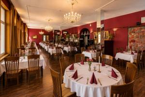a dining room with white tables and chairs at Kulturhotel Kaiserhof in Bad Liebenstein