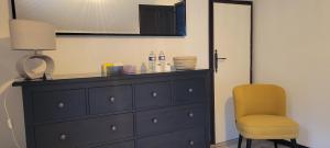 a bedroom with a dresser and a yellow chair at Chambres cosy au hameau de St Pierre in Saint-Georges-de-Commiers +33 photos