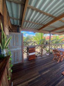 a porch with a table and a wooden deck at Pousada rancho sol nascente in Tutóia
