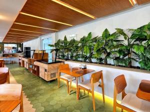 a restaurant with a table and chairs and plants on the wall at FLAT RESORT LUXO MALIA 215E- Porto de Galinhas - Muro Alto in Porto De Galinhas