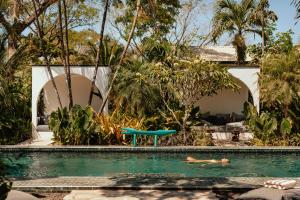 a couple swimming in a swimming pool in a house at Domo Nosara Boutique Hotel in Nosara