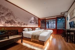 a bedroom with a large white bed and a desk at 木老爷客栈 in Lijiang