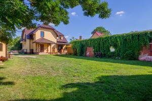 a house with ivy growing on the side of it at Dolistówka Apartamenty z jacuzzi i sauną in Goniadz