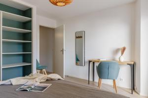 a room with a desk and a blue chair at Résidence Pierre & Vacances La Baie des Sables in Les Sables-d'Olonne