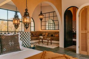 a bedroom with a bed and a couch and chandeliers at Domo Nosara Boutique Hotel in Nosara