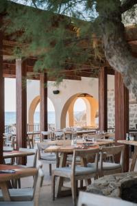 an empty restaurant with wooden tables and chairs at Hôtel Abbartello in Olmeto