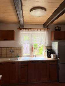 a kitchen with a window and a sink and a refrigerator at Dom w górach Zacisze lasu z prywatną balią in Sucha Beskidzka +45 photos