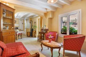a living room with red chairs and a table at Le Duzon avec Piscine in Saint-Sylvestre