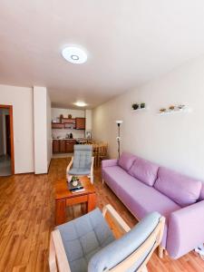 a living room with a purple couch and a table at Tranquil condo in Golden Sands in Varna City
