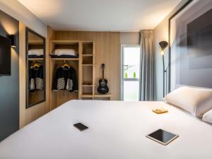 a bedroom with a bed and a guitar in a room at ibis Issoire in Issoire