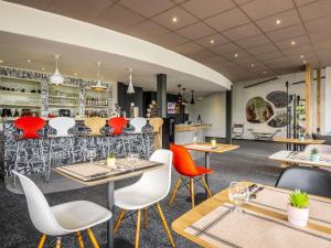 a restaurant with tables and chairs and a bar at ibis Issoire in Issoire +17 photos