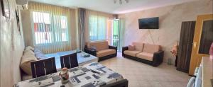 a living room with two couches and a couch and a table at Алекс 2 in Pomorie