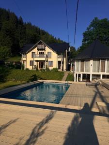 a house with a swimming pool in front of a house at Кільце Карпат in Verkhniy Yasenov