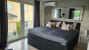 a bedroom with a bed with a mirror and a balcony at Gästehaus Ferienwohnung Abendstern in Rust