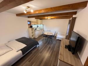 a bedroom with a bed and a table and a kitchen at Privat Beata in Hrabušice