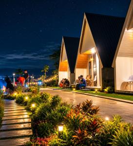a group of people sitting outside of a building at night at villa cabin vianda in Kejajar