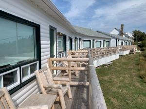 a row of wooden benches on the side of a building at Au Pic de l'Aurore Motel-Chalets in Perce