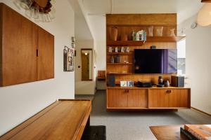 a living room with a tv and a wooden entertainment center at Hotell Hanöbris på Kivik in Kivik