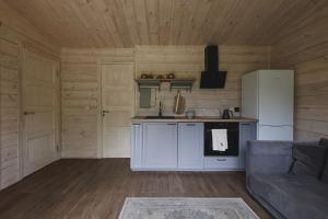 a kitchen with a refrigerator and a couch in a room at Obuoliu sala Moletu Vila in Gaylyunay