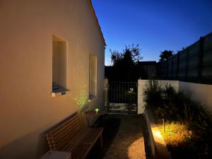 a building with a wooden bench in a yard at Chez Olivier et Damien in La Roche-sur-Yon