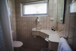 a bathroom with a toilet, sink, and bathtub at Hospitality Kalgoorlie, SureStay by Best Western in Kalgoorlie