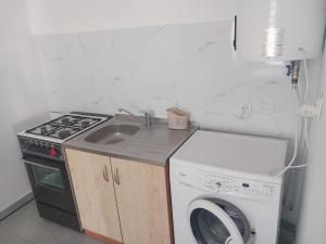 a kitchen with a sink and a washing machine at Noclegi Puńsk w centrum 50 m in Puńsk