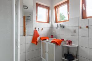 a white bathroom with orange towels on the counter at Chambre d'hôte La Châtelaine in Walbach +27 photos