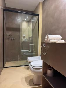 a bathroom with a toilet and a glass shower at Hotel Cerros del Norte in Tilcara