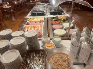 a buffet with white plates and food on a table at Hindenburg-Dependance Hotel Krone in Bad Gastein +15 photos
