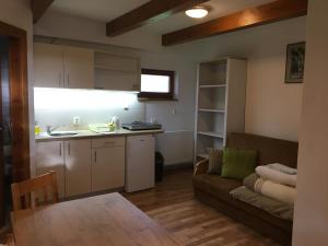 a kitchen and a living room with a couch and a table at Privat Beata in Hrabušice