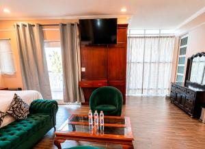 a living room with a couch and a tv at Hotel Cacaxtla Collection in Tlaxcala de Xicohténcatl