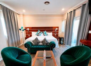 a hotel room with a bed and two green chairs at Hotel Cacaxtla Collection in Tlaxcala de Xicohténcatl