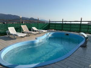 a swimming pool with two chairs at Hotel Royal Georgia 2 in Batumi