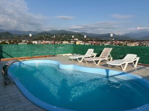 a swimming pool with chairs and a view of a city at Hotel Royal Georgia 2 in Batumi