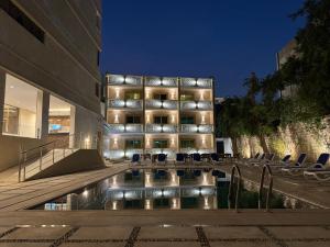 a building with a pool and chairs in front of it at Dyafa Pyramids Hotel in Cairo