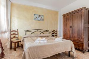 a bedroom with a bed and a wooden cabinet at Le Terre Di BAC in Borgo Montenero