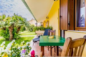 a green table and chairs on the balcony of a house at Le Terre Di BAC in Borgo Montenero +37 photos