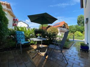 a table and two chairs and an umbrella on a patio at Ferienwohnung mit Salzachblick in Laufen