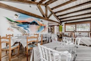 a dining room with tables and chairs and a painting on the wall at Le Terre Di BAC in Borgo Montenero