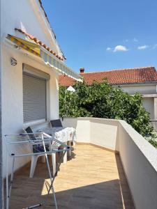 a balcony with a table and a chair on a building at Villa Sekki in Krk
