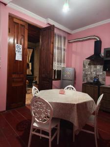 a dining room with a table and chairs and pink walls at Cozy home in Zugdidi +35 photos
