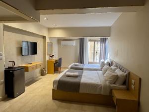 a bedroom with a large bed and a television at Dyafa Pyramids Hotel in Cairo