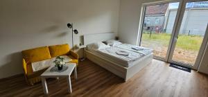 a bedroom with a bed and a couch and a table at Apartmán Meridiem Komárovská in Komárov